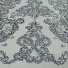 the fabric is made up of silver sequins and has an intricate design on it