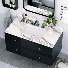 a bathroom sink sitting under a mirror next to a towel rack with flowers on it