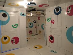 an art installation with colorful circles painted on the walls and doors, all in different colors