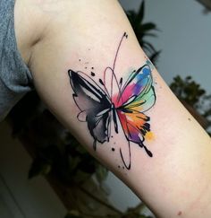 a colorful butterfly tattoo on the arm