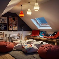 an attic bedroom with red bean bags on the floor and pictures hanging from the ceiling