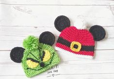 two crocheted mickey mouse hats on top of a white wooden table next to each other