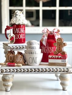 some mugs are sitting on a table with cookies and other items in front of them