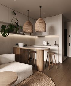 a living room and kitchen area with stools, table, sink and potted plant