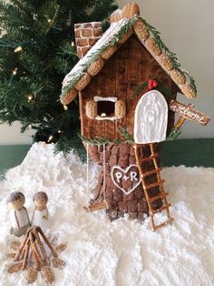 a gingerbread house is decorated with icing and other holiday decorations, including a ladder to the roof