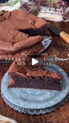 a piece of chocolate cake sitting on top of a wooden table next to a knife