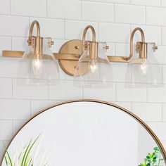 a bathroom vanity light with three clear glass shades