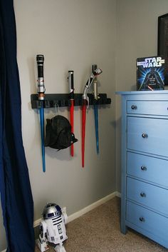 a star wars themed bedroom with blue dresser and toy r2d2 action figure