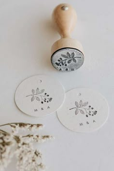 two rubber stamps with floral designs on them next to some dried flowers and a wooden stamp