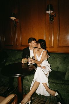 a man and woman sitting on a couch kissing