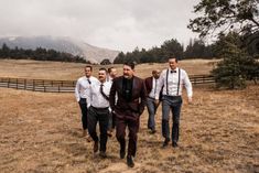 a group of men walking across a grass covered field