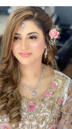 a woman with long hair wearing a flower in her hair and jewelry on her head