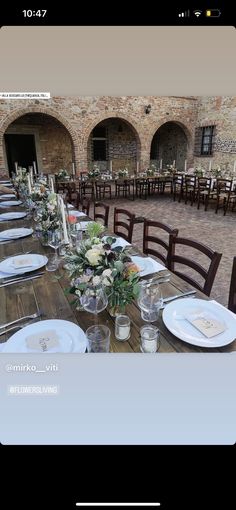 the table is set with place settings and flowers on it for an elegant dinner party