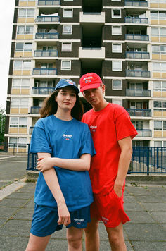 a man and a woman standing in front of a tall building Royal Blue Shorts, Sport Design, Woven Labels, Female Model, Sports Design, East London, Blue Shorts, Male Model, Unique Fashion