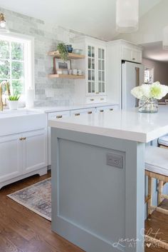 a kitchen with white cabinets and an island