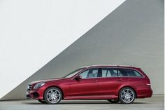 a red mercedes benz wagon parked in front of a wall