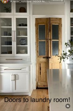 a kitchen with white cabinets and wood floors