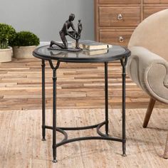 a small table with a book on it in front of a chair and wooden floor