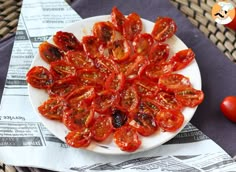 a white plate topped with sliced tomatoes on top of a table