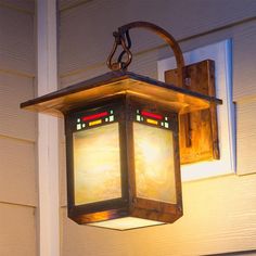 a light hanging from the side of a house on a wall next to a door