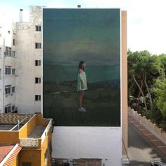 a woman standing on top of a building next to a large poster in the air