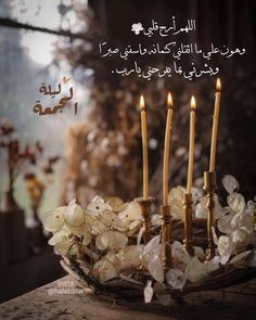 a cake with candles and flowers on it in front of an arabic quote that reads,