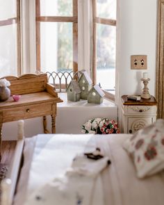 there is a bed, dresser and window in the room with flowers on the table