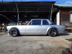 an old silver car parked in front of a building