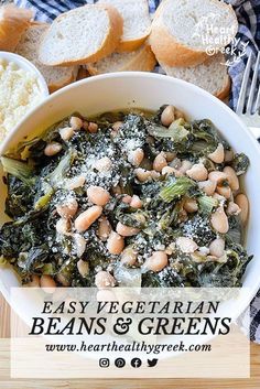 a white bowl filled with beans and greens next to bread on a cutting board in front of it