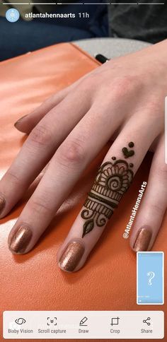 a woman's hand with henna tattoos on it