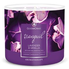 an aroma candle with purple flowers in the middle and white lettering that reads tranquil lavender