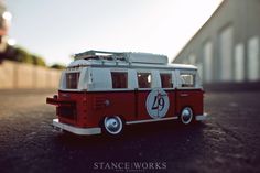 a red and white toy bus sitting on top of a street