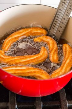 onion rings frying in oil on the stove with a measuring tape sticking out of it