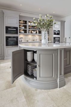 a large kitchen with an island in the middle and lots of cabinets on both sides