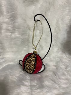 a red and black animal print purse on a white fur background