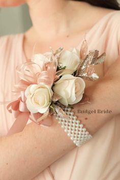 a woman wearing a pink dress holding a bouquet of flowers and pearls on her arm