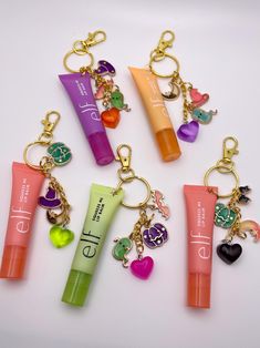 Apply your gloss in style with these fun lip gloss keychains! These make great gifts for your besties, teachers and boo baskets.  Each keychain comes with a large lobster clasp and chain of 4 Halloween-themed charms. Charms are all chosen at random. If you have a preference on which charms you would like, feel free to send me a message and I will do my best to accommodate your requests based on what I have available.  Purchase Options: 1) Keychain only- this option does not include lip gloss and only the chain & charms will be sent to you. You will need to supply your own gloss.  2) Keychain + Gloss- this option includes the lip gloss and keychain with charms. The lip gloss included will be the same brand as in the listing photos and attached to the keychain. Cute Small Cheap Gifts, Elf Lip Gloss Keychain, Charms On Lip Gloss, Lipgloss Charm Keychain, Lip Gloss Keychain Ideas, Lip Gloss With Charms, Lip Gloss Charm Diy, Lip Balm Charm Keychain, Chapstick Charms