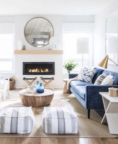 a living room filled with furniture and a fire place in the middle of the room