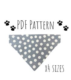 a gray and white polka dot dog bandana with black paw prints on the front