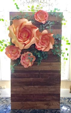 an arrangement of flowers is displayed on a wooden block in the middle of a room