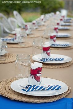 the table is set with plates and glasses for an outdoor dinner or party event in blue, white and red