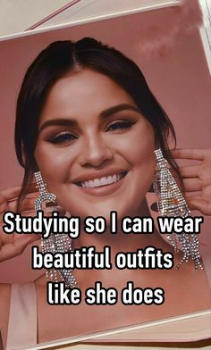 a woman smiling and holding up her earrings with the words studying so i can wear beautiful outfits like she does