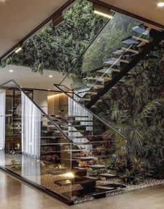 an indoor stair case with plants growing on the wall and stairs leading up to it