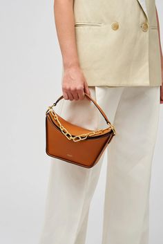 [vc_row][vc_column width=”1/3″][vc_column_text text_larger=”no”] Oroton Women’s Fable Small Day Bag   Oroton Fable Small Day Bag The Oroton Fable Small Day Bag, crafted from smooth leather and lined with 100% cotton twill, it exudes sophistication. The brass colour hardware and signature foil embossed logo add an elegant touch. This bag features one compartment with an internal card sleeve pocket for easy organisation. Designed with a removable top handle, a ch Cognac Evening Bag With Top Carry Handle, Modern Square Bucket Bag With Gold-tone Hardware, Chic Cognac Evening Bag, Chic Cognac Rectangular Shoulder Bag, Chic Rectangular Cognac Shoulder Bag, Trendy Rectangular Cognac Bag, Trendy Cognac Rectangular Bag, Cognac Rectangular Hobo Bag With Detachable Handle, Cognac Hobo Bag With Detachable Handle