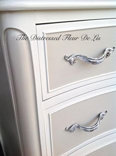 a white dresser with silver handles and drawers