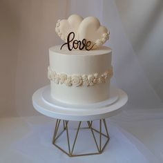 a wedding cake with two hearts on top