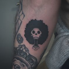 a skull with an afro on its arm