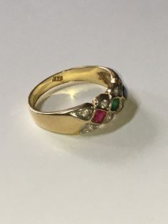 Beautifully vintage. Solid, stamped 14K Yellow Gold band ring. Features round cut red Ruby, blue Sapphire, green Emerald gemstones with round cut stones, possibly faux diamonds or topaz. Ring and stones show use, wear, and imperfections commensurate with age. Do not have any additional information on the stones. Ring size approximately 6.5. Vintage Multi-stone Ruby Promise Ring, Vintage Multi-stone Gold Ring, Vintage Multi-stone Diamond Rings, Vintage Gold Multi-stone Ring, Vintage Multi-stone Sapphire Ring, Vintage Red Multi-stone Diamond Ring, Vintage Multi-stone Round Emerald Ring, Vintage Multi-stone Emerald Ring, Vintage Multi-stone Diamond Ring In Yellow Gold