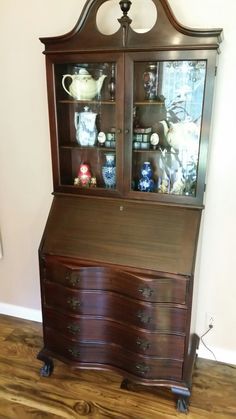 a wooden desk with glass doors and drawers