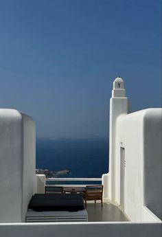 a white building with a clock tower next to the ocean